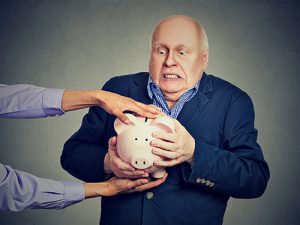 Picture of a guy holding on to his piggy bank